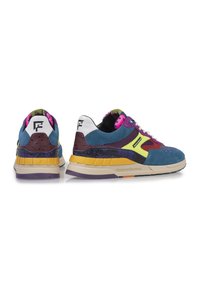 Zapatillas deportivas multicolores que combinan materiales de ante y malla, con detalles en azul, morado, amarillo y rosa, y paneles texturizados.