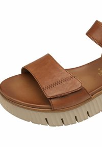 Sandalia de cuero marrón con tira frontal ancha, plantilla acolchada y suela gruesa beige con relieve, diseñada para comodidad y uso informal.