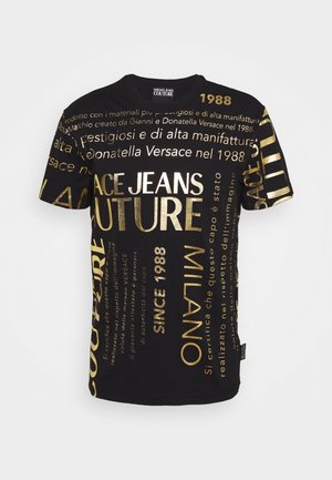 Czarny t-shirt z krótkim rękawem z złotym napisem zawierającym "Versace Jeans Couture," "Since 1988," oraz włoskie frazy w różnych rozmiarach i orientacjach.