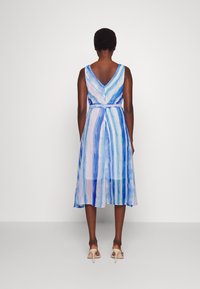 Vestido sin mangas con escote en V en tonos azul claro y rayas de acuarela en morado, que presenta una cintura ajustada y una falda flotante de longitud media.