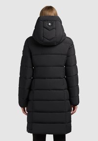 Abrigo acolchado negro con capucha de patrón en forma de chevron, diseño acolchado, mangas largas y un detalle de cremallera en el dobladillo.