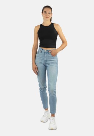 Black crop tank top, light blue high-waisted jeans, white sneakers. Smooth fabric, fitted design, minimal details, and classic shape.