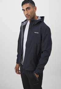 Calvin Klein Golf FEATHER DRY WATERPROOF SHELL JACKET - Regnjakke - black