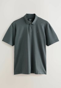 Sötétszürke galléros póló, rövid ujjakkal és diszkrét logóval a mellkason. Sima anyag, normál szabással és gombos légzéssel.