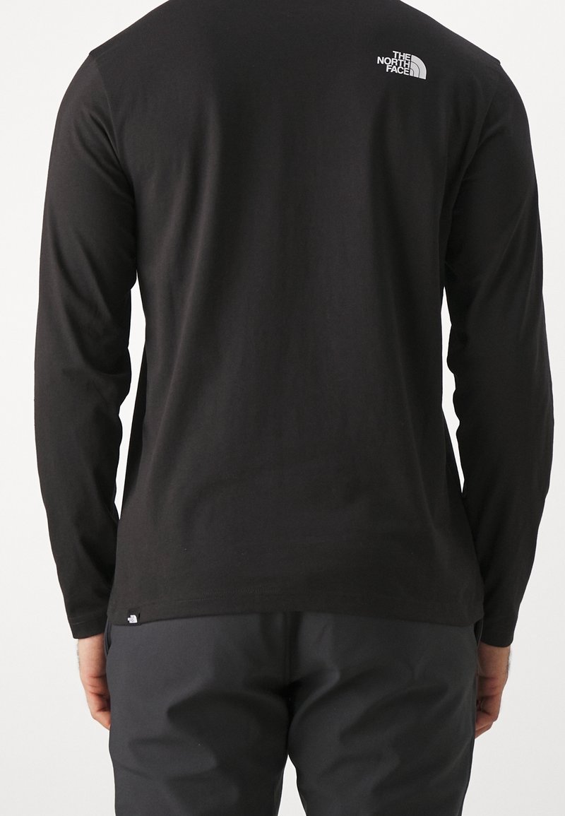 Schwarzes langärmeliges T-Shirt aus Baumwolle mit kleinem weißem Logo auf dem oberen Rücken und lockerem Schnitt. Keine auffälligen Muster oder Texturen.