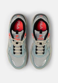 Sneaker atletici blu chiaro e grigi con pannelli in rete, accenti riflettenti, bordi neri e suole beige; presenta il logo Fila in rosso.