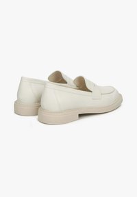 Białe skórzane buty wsuwane z okrągłym noskiem, z przeszywaną podeszwą i jasną gumową podeszwą. Minimalistyczny design bez wzorów.