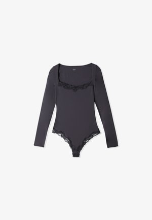 Czarny body z długim rękawem, kwadratowym dekoltem i koronkowym wykończeniem na klatce piersiowej oraz przy otworach na nogi, na białym tle.