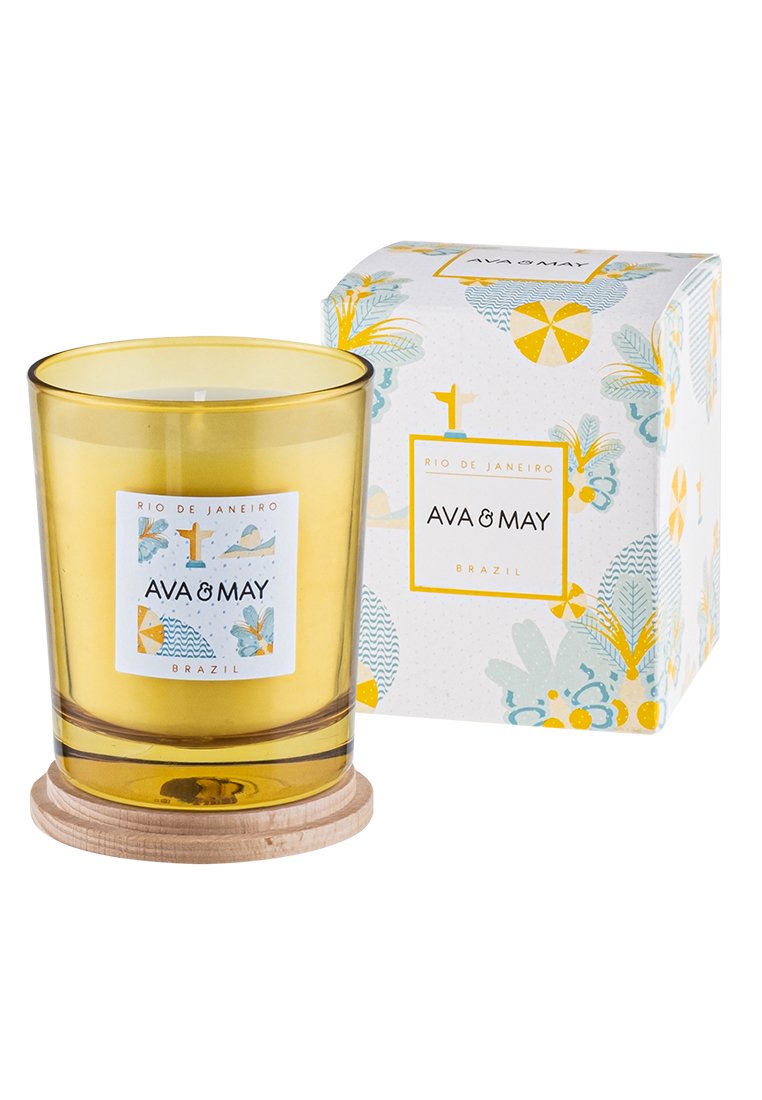 Gelbe Glaskerze mit einem Holzsockel; verfügt über ein dekoratives Etikett und eine Verpackung mit floralen und geometrischen Mustern in Blau und Gelb.