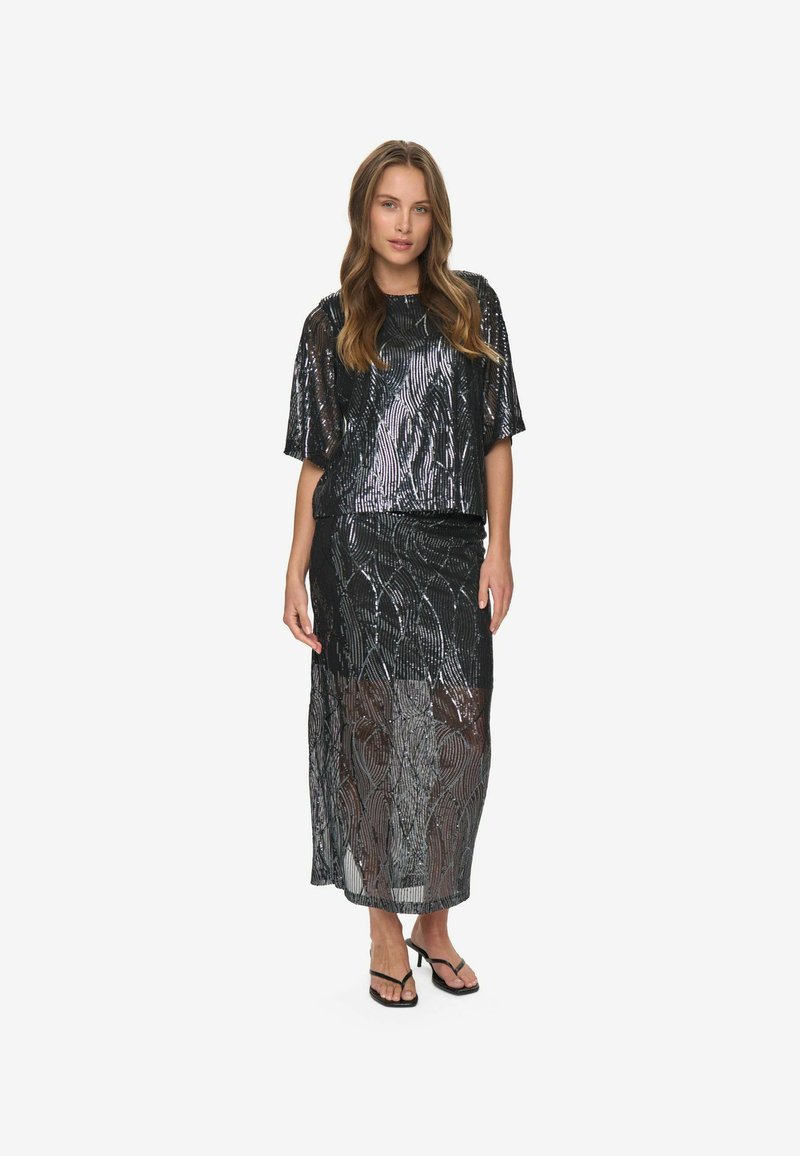 Ensemble deux pièces composé d'un haut noir à manches courtes et d'une longue jupe, tous deux confectionnés en sequins réfléchissants avec des motifs en spirale, dotés de fines bretelles aux épaules et aux chevilles.