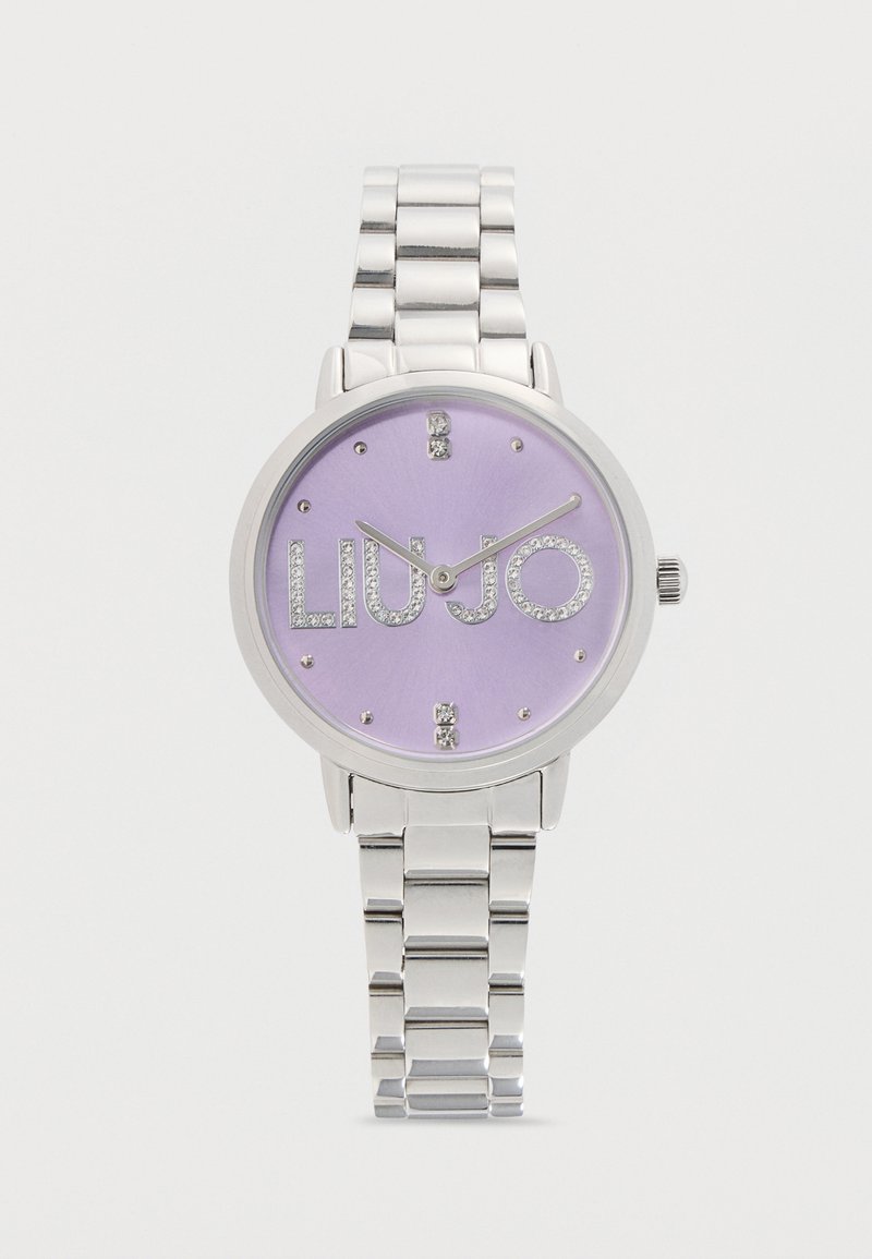 Montre-bracelet en métal argenté avec cadran lilas, index horaires en cristal et logo "LIU JO" orné de cristaux sur le cadran.