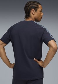 Marineblå kortærmet t-shirt i bomuldsblanding med mønstret detalje langs skuldrene, med klassisk rund hals og afslappet pasform.