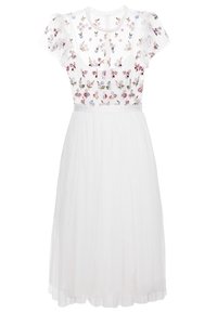 Valkoinen mekko, jossa kukkakirjailu läpikuultavalla yläosalla, lyhyet pitsihihat ja hulmuava tyllihame. Yksinkertainen pyöreä pääntie.