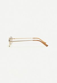 Gold-tone metal sunglasses with round lenses, thin arms with a slight curve, and a textured design on the tips. Transparent frame accents.