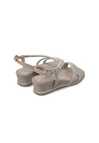 Sandali wedge in suede color taupe chiaro con dettagli in tono argento e una soletta testurizzata. Cinghietta alla caviglia regolabile per una vestibilità perfetta.
