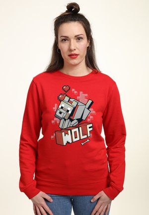 Czerwona bluza z kapturem z pikselowym wzorem wilka oraz napisem "WOLF" w białym i czarnym obrysie na prostym tle.