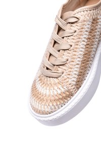 Sneaker intrecciato beige con accenti bianchi, punta tonda, tomaia testurizzata e lacci piatti. Caratterizzato da una suola in gomma bianca e motivi intricati.