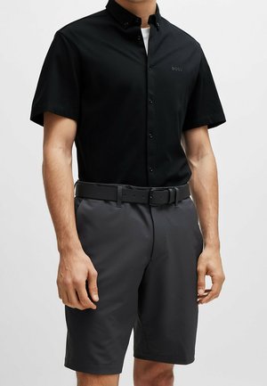 Short-sleeve black button-up shirt with a collar, paired with dark gray shorts. Features a subtle logo on the shirt and a belt.