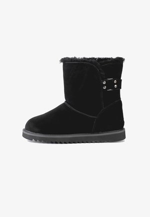 Stivale in suede nero con finitura testurizzata, caratterizzato da un colletto foderato in pelliccia, accessori in metallo con fibbia laterale e suola in gomma scanalata.