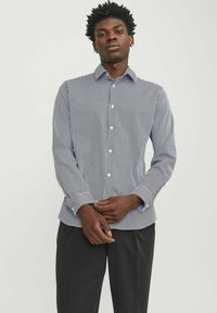 Camicia button-up a righe verticali blu navy e bianche, realizzata in tessuto leggero, presenta un colletto a punte e maniche lunghe con polsini a bottone.