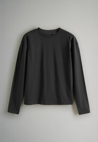 T-shirt a maniche lunghe in cotone nero con collo a giro, vestibilità rilassata e texture morbida. Presenta cuciture minime e nessun motivo o dettaglio visibile.