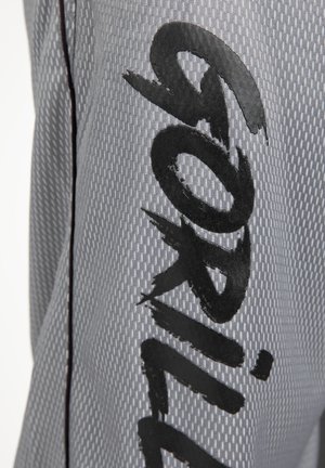 Gray textured fabric with a repeating pattern, featuring bold black lettering. Design includes a contrasting black side seam.