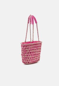 Sac à main tissé rose avec poignées en chaîne argentée et bretelles d'épaule en cuir rose rembourrées sur fond blanc.