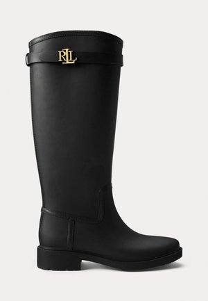Schwarzer Gummistiefel in Knielänge mit flacher Sohle, glanzvollem Finish und einem goldenen Logoakzent nahe der Oberkante. Verfügt über eine glatte Textur und ein elegantes Design.