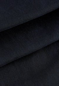 Ciemnoniebieska tkanina o gładkiej fakturze, złożona tak, aby pokazać jej grubość. Materiał wydaje się lekko szczotkowany z minimalnym połyskiem.