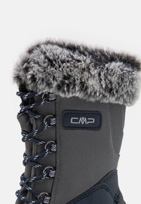 Botte d'hiver grise avec un col en fausse fourrure, des œillets renforcés et des lacets contrastants. Logo CMP affiché sur le côté. Texture douce.