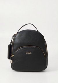 Sac à dos en cuir noir de forme arrondie, avec des fermetures éclair dorées et un détail de logo. Il est équipé d'une poignée supérieure et de bretelles réglables.