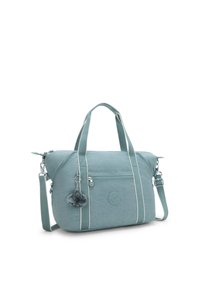 Teal bag with a textured finish, white stripes, dual handles, and a detachable fluffy charm. Features a zippered pocket and adjustable strap.
