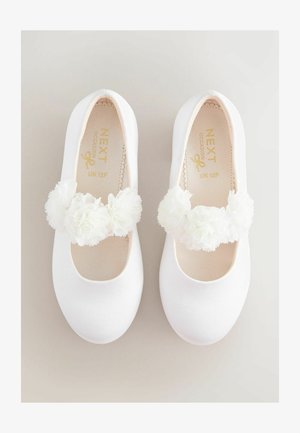 Białe baletki z satynowym wykończeniem, ozdobione podwójną warstwą białych kwiatowych dekoracji na pasku oraz miękką, wyściełaną wkładką.