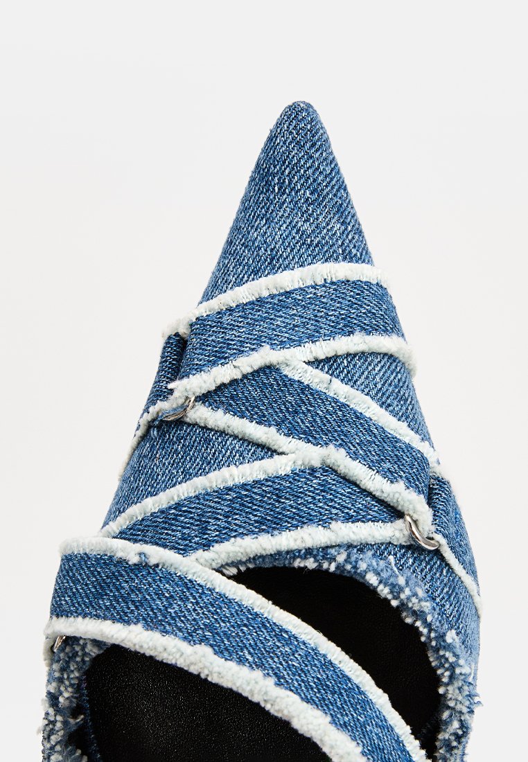 Scarpa a punta coperta in denim blu con bordi bianchi sfilacciati e cinghie incrociate sulla parte superiore.