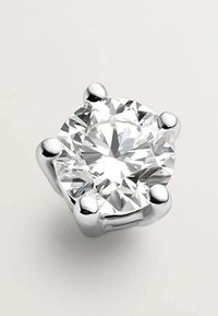 Pendiente de perno de diamante redondo con una superficie clara y facetada. Montado en un soporte de metal plateado pulido con cuatro acentos similares a garras.