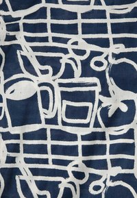 Contours blancs abstraits de tasses à café et de fleurs sur un fond de tissu bleu foncé à motif quadrillé.