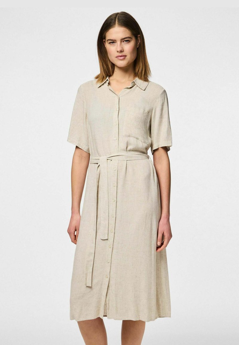 Vestito camicia in lino beige con bottoni frontali, maniche corte, vita con cintura e orlo a metà ginocchio, dal taglio morbido.