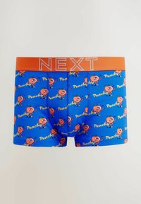 Siniset boxerit, joissa on oranssi "NEXT" vyötärö, ja joiden kankaassa on leikkisä persikkahahmo sekä sana "Peachy" keltaisella tekstillä.