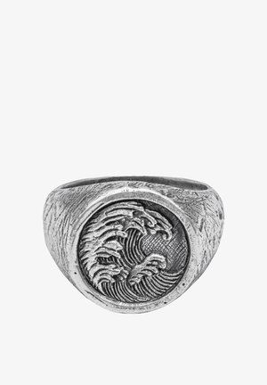 Anneau en argent présentant un motif circulaire de vagues avec des détails texturés. Anneau lisse et vagues en relief créant un motif contrasté.