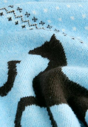Strikket sweater i lyseblå med mørkebrune dyremønstre. Har en blød tekstur og et spredt stjerne-motiv i hvidt over stoffet.