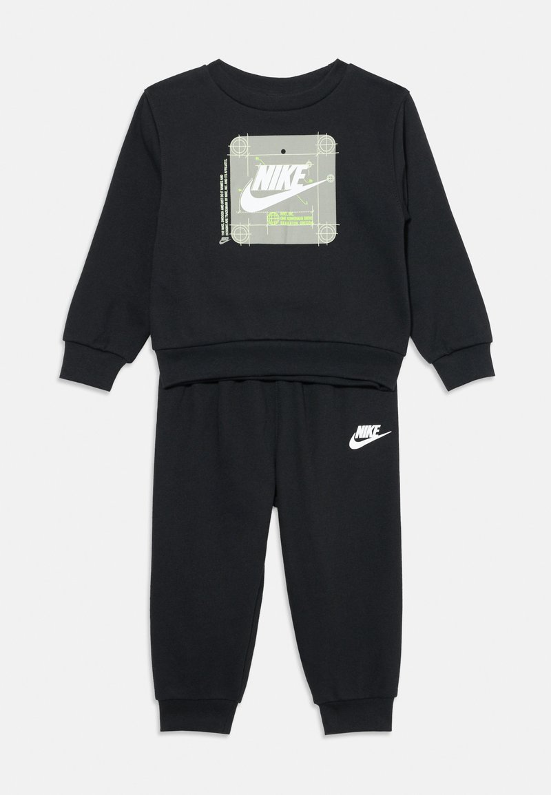 Ensemble de survêtement Nike noir avec un logo graphique sur le haut et un détail logo sur le bas. Fabriqué en tissu doux, avec des poignets et une taille côtelés.