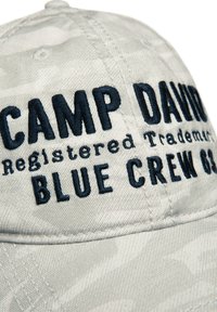 Lichtgrijze pet van een gestructureerde stof, met marineblauwe geborduurde tekst: "CAMP DAVID Handelsmerk BLUE CREW 03."