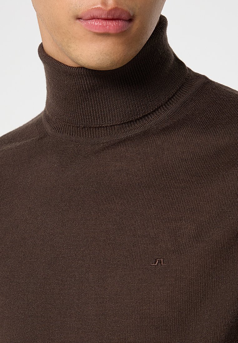 Brązowy sweter z golfem w teksturowanej dzianinie. Posiada dopasowany krój oraz małe haftowane logo na klatce piersiowej.