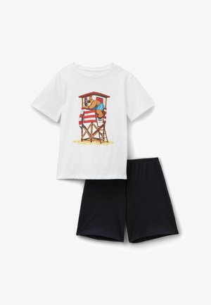 Weißes kurzärmeliges Hemd mit Grafik eines Bären, der auf einem Rettungsschwimmerturm liegt, kombiniert mit schlichten schwarzen Shorts.