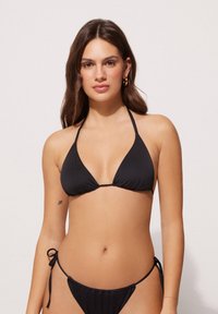 Set di bikini nero, composto da un top triangolare con spalline sottili e un bottom con chiusure a nastri sui lati, realizzato in tessuto morbido.