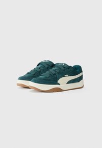 Baskets en daim teal avec des accents crème et une semelle en caoutchouc gomme. Présente un design à lacets et un logo PUMA sur le côté.