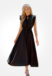 Černé maxi šaty s nařaseným korzetem, volánkovými rukávy a opaskem na zavázání. Mají splývavou sukni a strukturovanou látku.