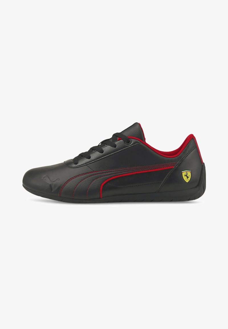 Baskets Puma basses noires avec accents rouges, lacets noirs et logo Ferrari au talon, vues de profil sur fond blanc.