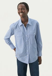 Light blue and white striped button-up shirt with two chest pockets, collared neckline, and long sleeves. Features straight hem and cuffed wrists.