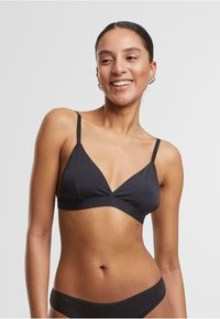 Črni bikini vrh s trikotno obliko, ožjimi nastavljivimi naramnicami in gladko teksturo tkanine. Ima preprost, minimalističen slog.
